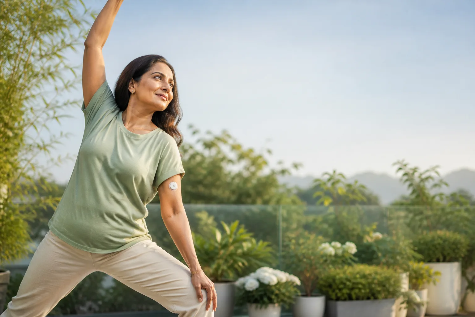Woman doing yoga on a terrace with a LinX CGM sensor discreetly worn on her arm